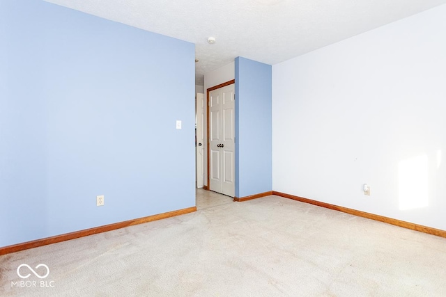 empty room with light carpet and a textured ceiling