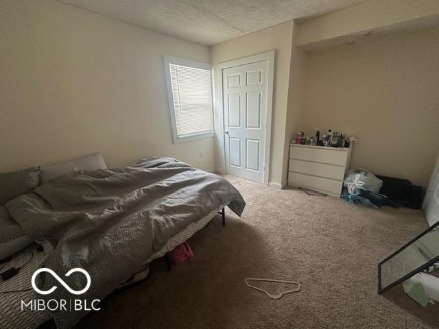 bedroom with a textured ceiling and carpet