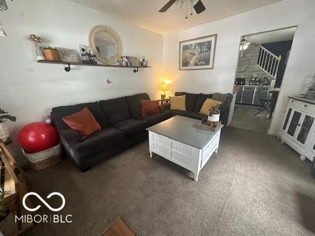 living room featuring dark colored carpet and ceiling fan