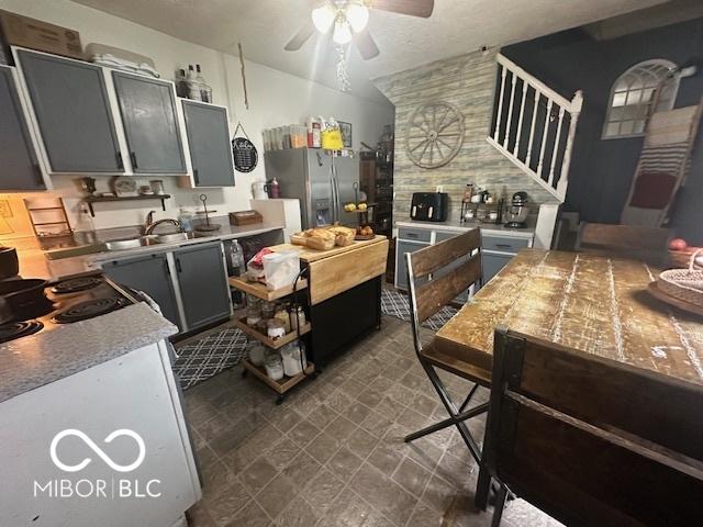 kitchen with sink, gray cabinets, ceiling fan, stainless steel fridge with ice dispenser, and decorative backsplash