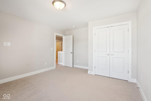 unfurnished bedroom featuring light colored carpet and a closet