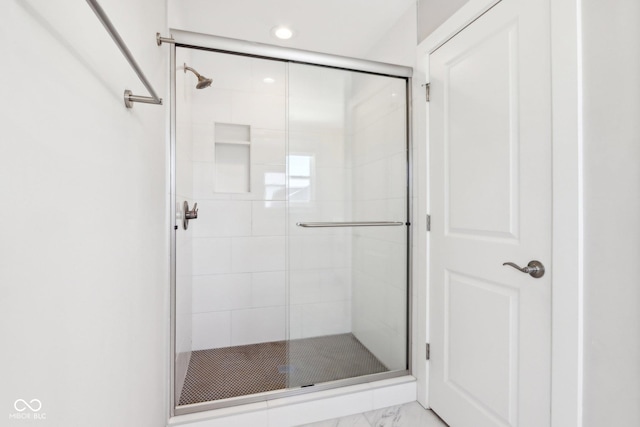 bathroom featuring a shower with door