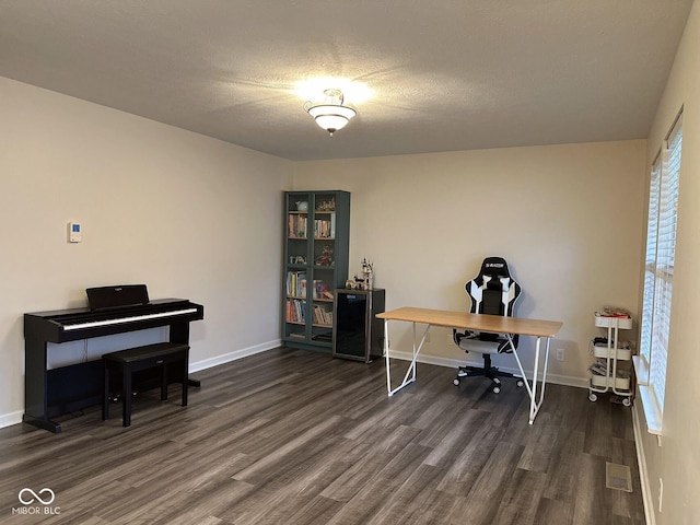 office with dark wood-type flooring and a textured ceiling