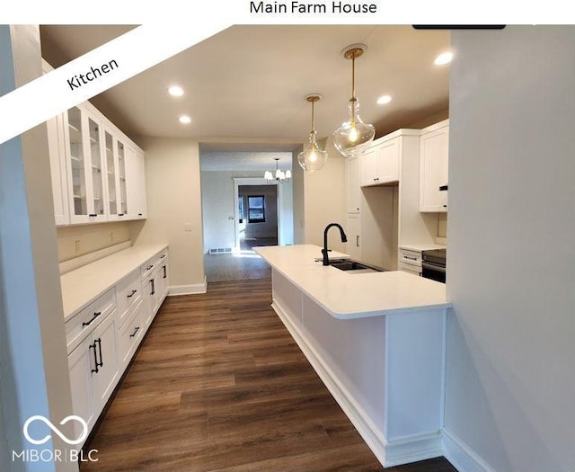 kitchen with sink, dark hardwood / wood-style floors, hanging light fixtures, and white cabinets