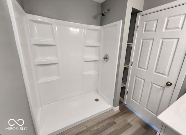 bathroom with hardwood / wood-style flooring and a shower