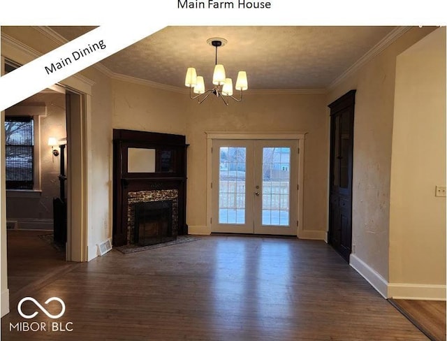 unfurnished living room featuring dark wood-type flooring, crown molding, a chandelier, and french doors