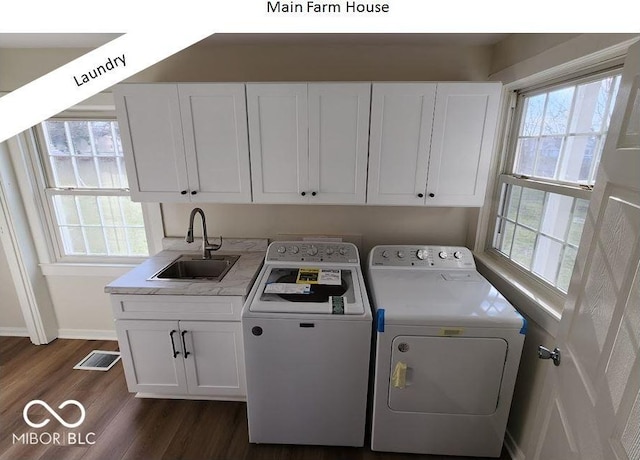 clothes washing area featuring cabinets, washing machine and clothes dryer, dark wood-type flooring, and sink