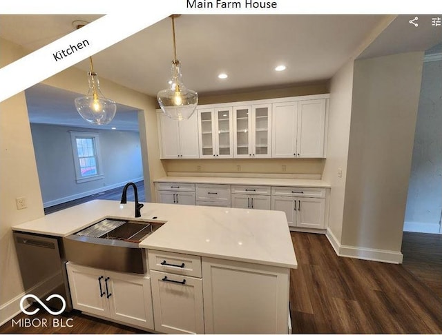 kitchen with dishwashing machine, sink, dark hardwood / wood-style floors, white cabinets, and decorative light fixtures