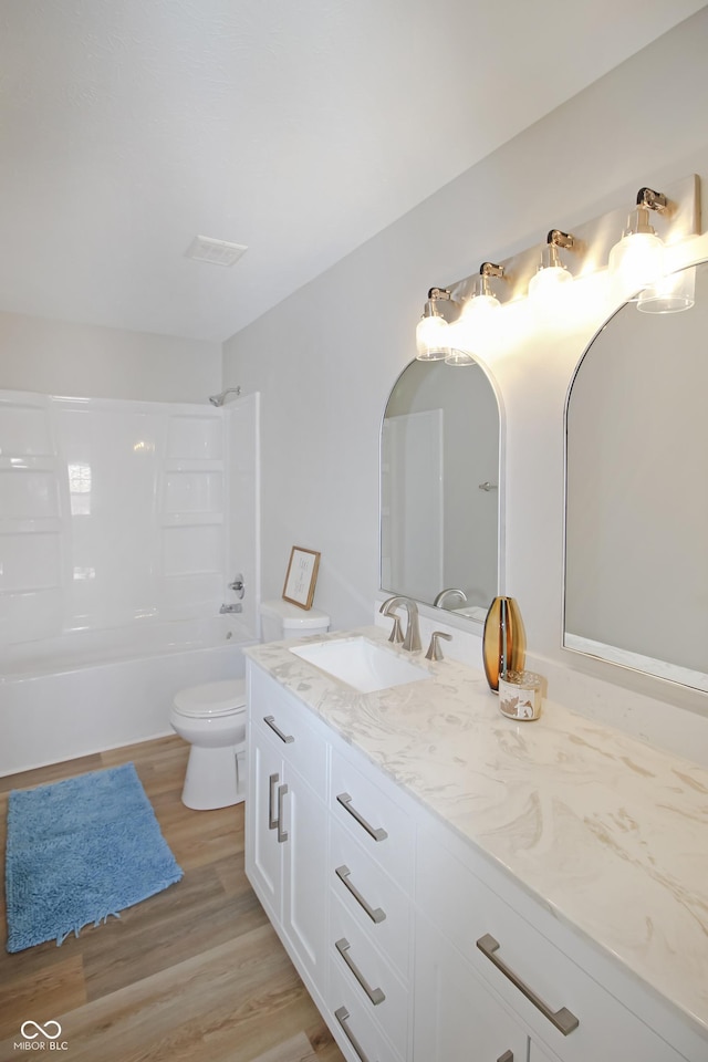 full bathroom featuring hardwood / wood-style flooring, shower / bathtub combination, vanity, and toilet