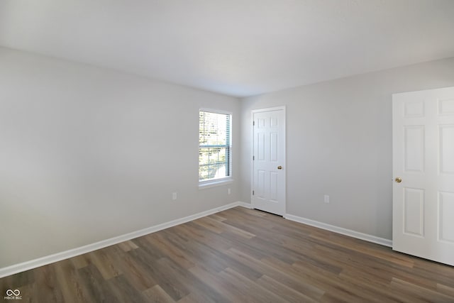 unfurnished room with dark wood-type flooring