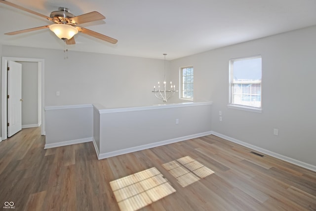 spare room with a chandelier and hardwood / wood-style floors