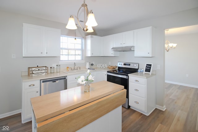 kitchen featuring white cabinetry, decorative light fixtures, and appliances with stainless steel finishes