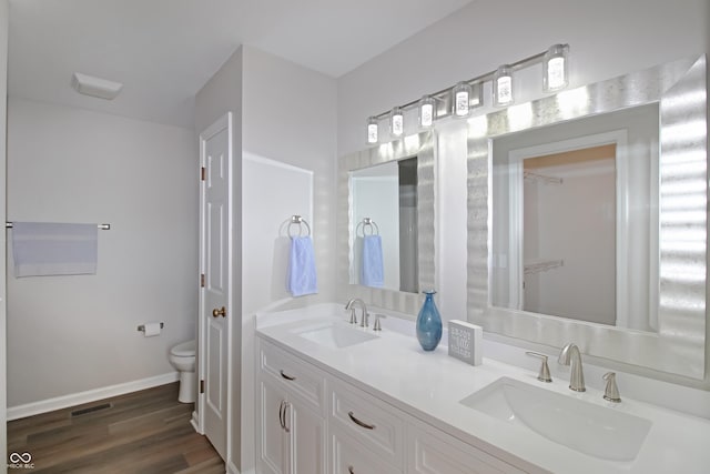 bathroom with wood-type flooring, vanity, and toilet