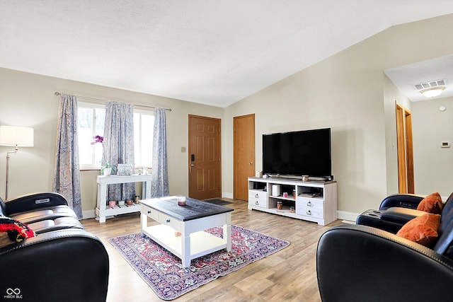 living room with lofted ceiling and light hardwood / wood-style flooring