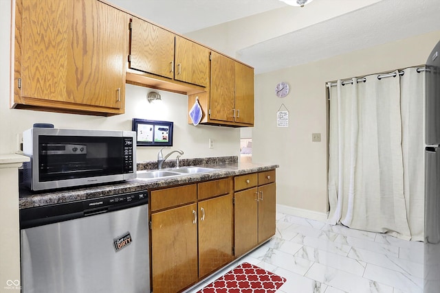 kitchen featuring stainless steel appliances, sink, and a textured ceiling