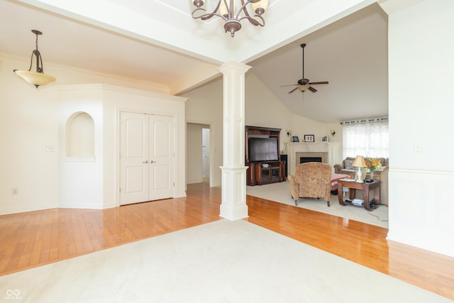 living room with hardwood / wood-style flooring, a tile fireplace, decorative columns, lofted ceiling with beams, and ceiling fan with notable chandelier