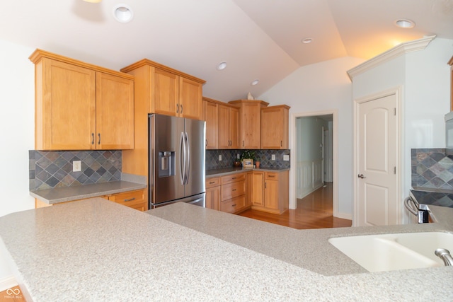 kitchen featuring tasteful backsplash, lofted ceiling, appliances with stainless steel finishes, and kitchen peninsula