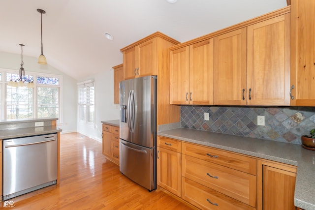 kitchen with decorative light fixtures, vaulted ceiling, stainless steel appliances, light hardwood / wood-style floors, and decorative backsplash