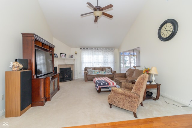 carpeted living room with ceiling fan, a fireplace, and high vaulted ceiling