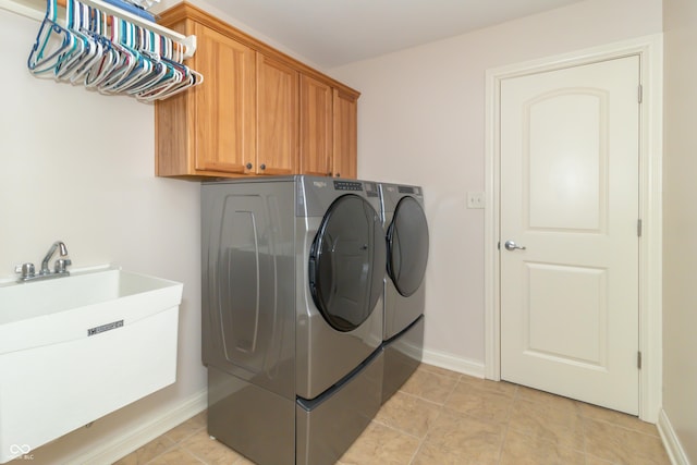 laundry room with cabinets, sink, washer and dryer, and light tile patterned floors