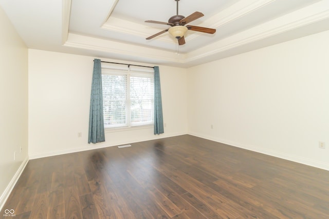 spare room featuring ceiling fan, ornamental molding, dark hardwood / wood-style floors, and a raised ceiling