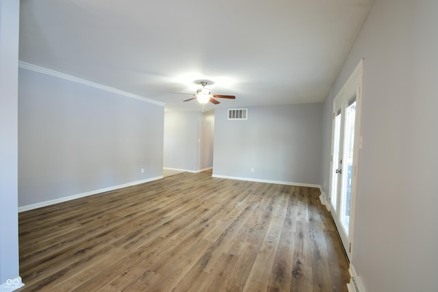 unfurnished room featuring ceiling fan, wood-type flooring, and ornamental molding