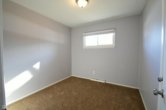 empty room with a baseboard heating unit and dark carpet