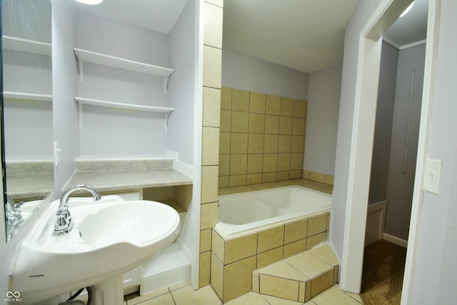 bathroom with sink, tiled bath, and tile patterned flooring