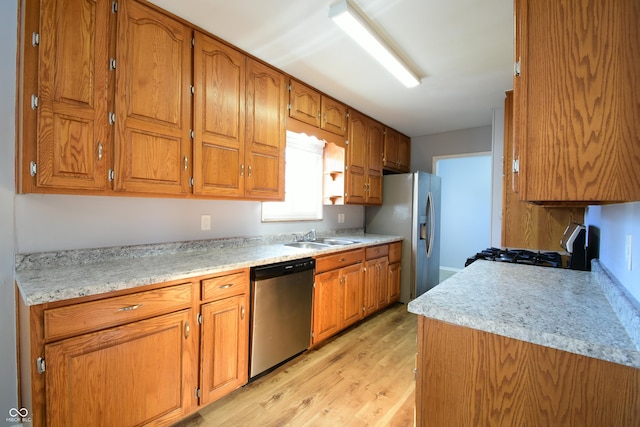 kitchen with stainless steel appliances, light hardwood / wood-style floors, and sink