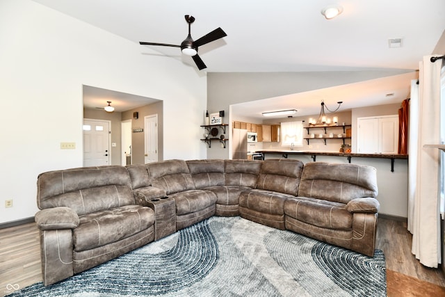 living room featuring light hardwood / wood-style flooring, vaulted ceiling, and ceiling fan