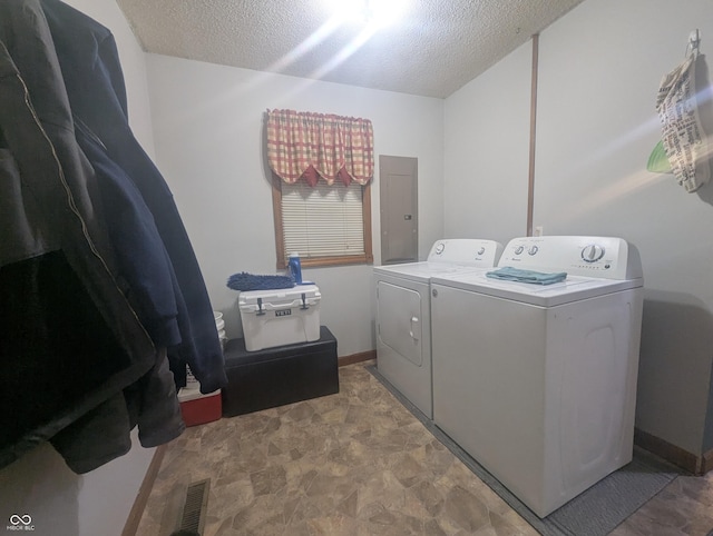 washroom with electric panel, independent washer and dryer, and a textured ceiling