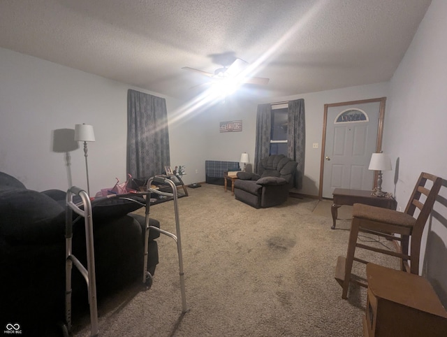 carpeted living room with ceiling fan and a textured ceiling