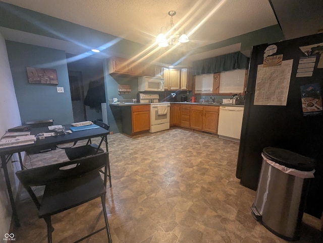 kitchen with sink, a notable chandelier, and white appliances