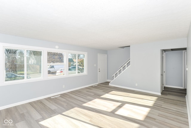 empty room featuring a textured ceiling and light wood-type flooring