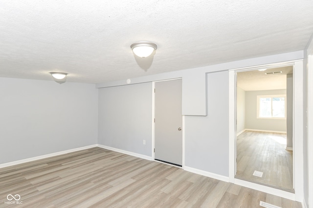 interior space with a textured ceiling and light wood-type flooring