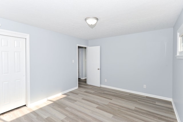 unfurnished bedroom featuring light hardwood / wood-style floors and a textured ceiling