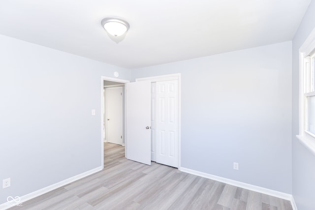 unfurnished bedroom featuring light hardwood / wood-style floors and a closet