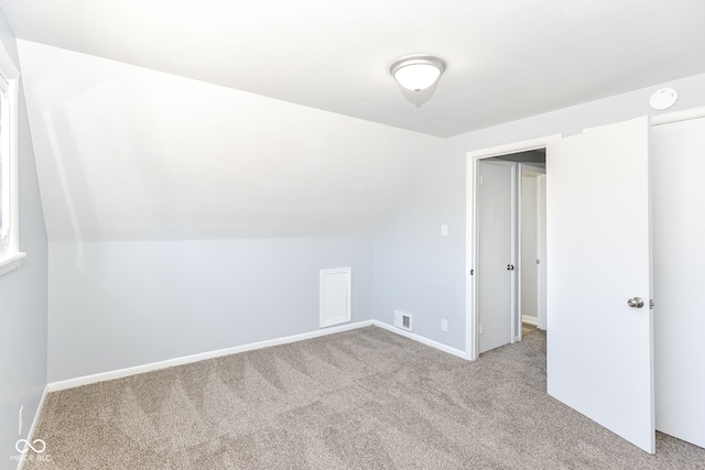 additional living space with lofted ceiling and light carpet