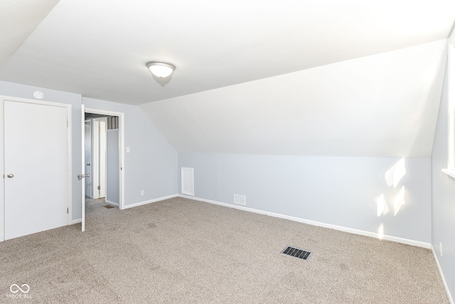 bonus room with lofted ceiling and carpet flooring