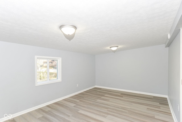 spare room with light hardwood / wood-style flooring and a textured ceiling