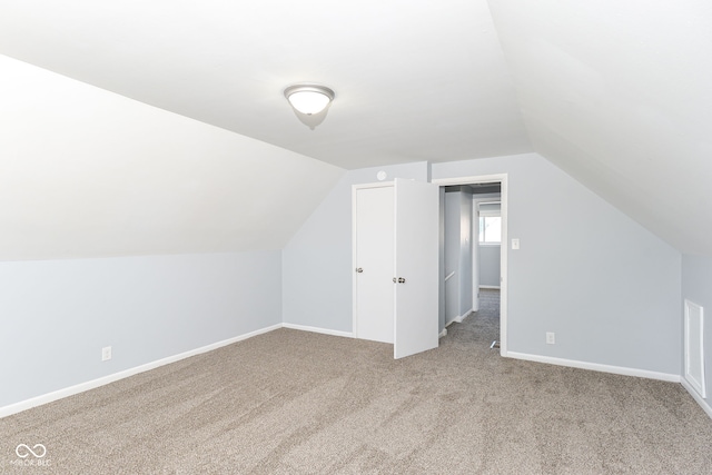 additional living space featuring lofted ceiling and carpet floors