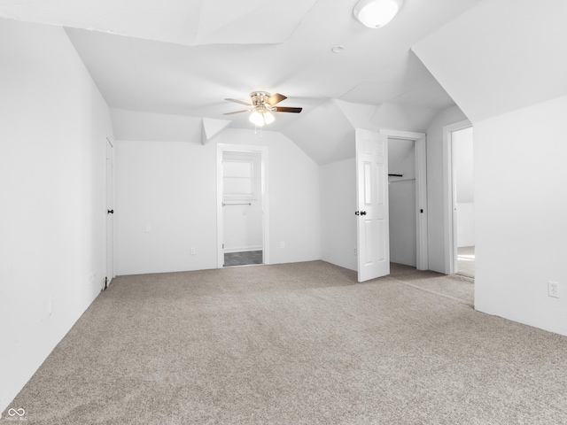 bonus room with lofted ceiling, light colored carpet, and ceiling fan