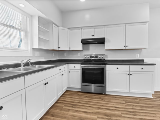 kitchen featuring hardwood / wood-style flooring, sink, white cabinets, and stainless steel range with electric stovetop