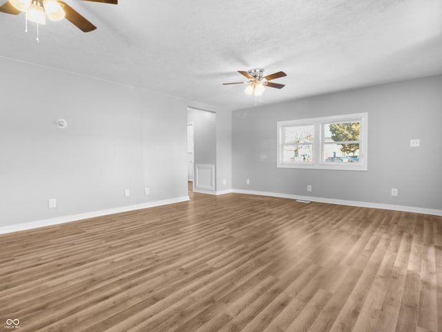 empty room featuring hardwood / wood-style floors, a textured ceiling, and ceiling fan