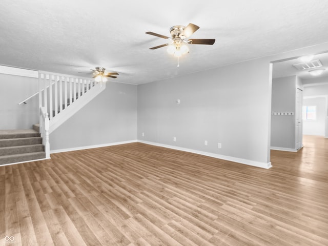 unfurnished living room featuring a textured ceiling, light hardwood / wood-style floors, and ceiling fan