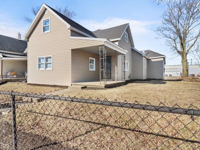 rear view of property featuring a yard and a patio area