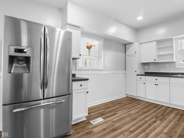 kitchen with white cabinetry, dark hardwood / wood-style flooring, and stainless steel refrigerator with ice dispenser