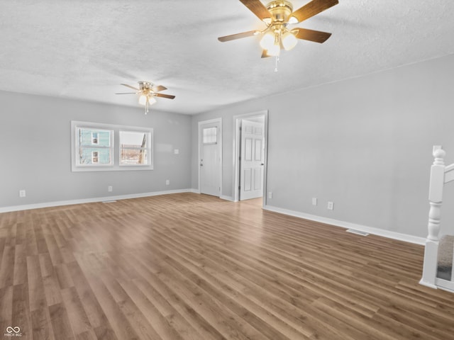 unfurnished living room with ceiling fan, hardwood / wood-style floors, and a textured ceiling