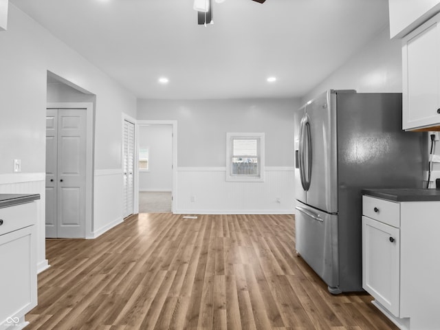 kitchen featuring stainless steel refrigerator with ice dispenser, white cabinetry, wood-type flooring, and ceiling fan