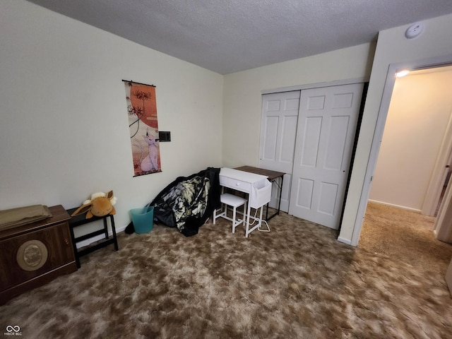 misc room featuring dark carpet and a textured ceiling